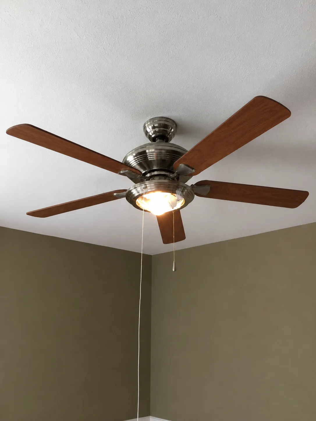 Finished ceiling fan installation with wood blades and integrated light fixture