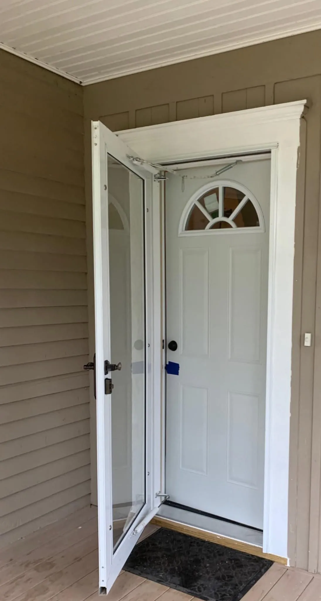 After: bright white replacement exterior entry door with an open storm door