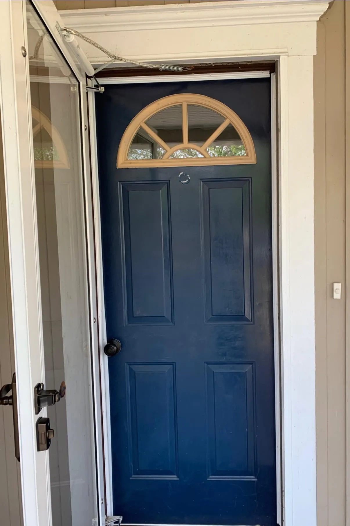 Before: dark blue exterior entry door with an open storm door