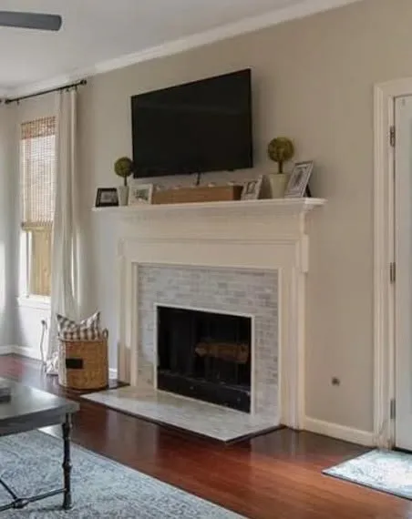 Before: living room fireplace with a traditional white mantel and tiled surround